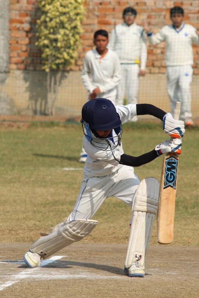 A young cricket player bats during a game on a sunny day in Gurugram, India.